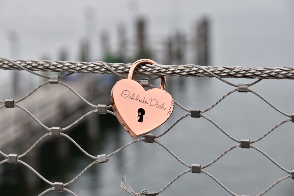 red heart padlock on gray metal fence during daytime