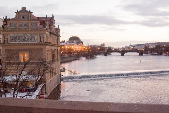 brown concrete building near body of water during daytime in Vltava Czech Republic