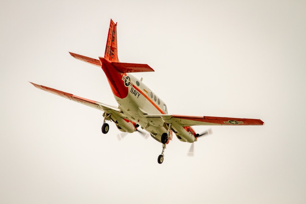 red and white airplane in mid air