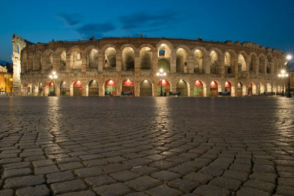 Brown concrete building during night time — Verona, Italy