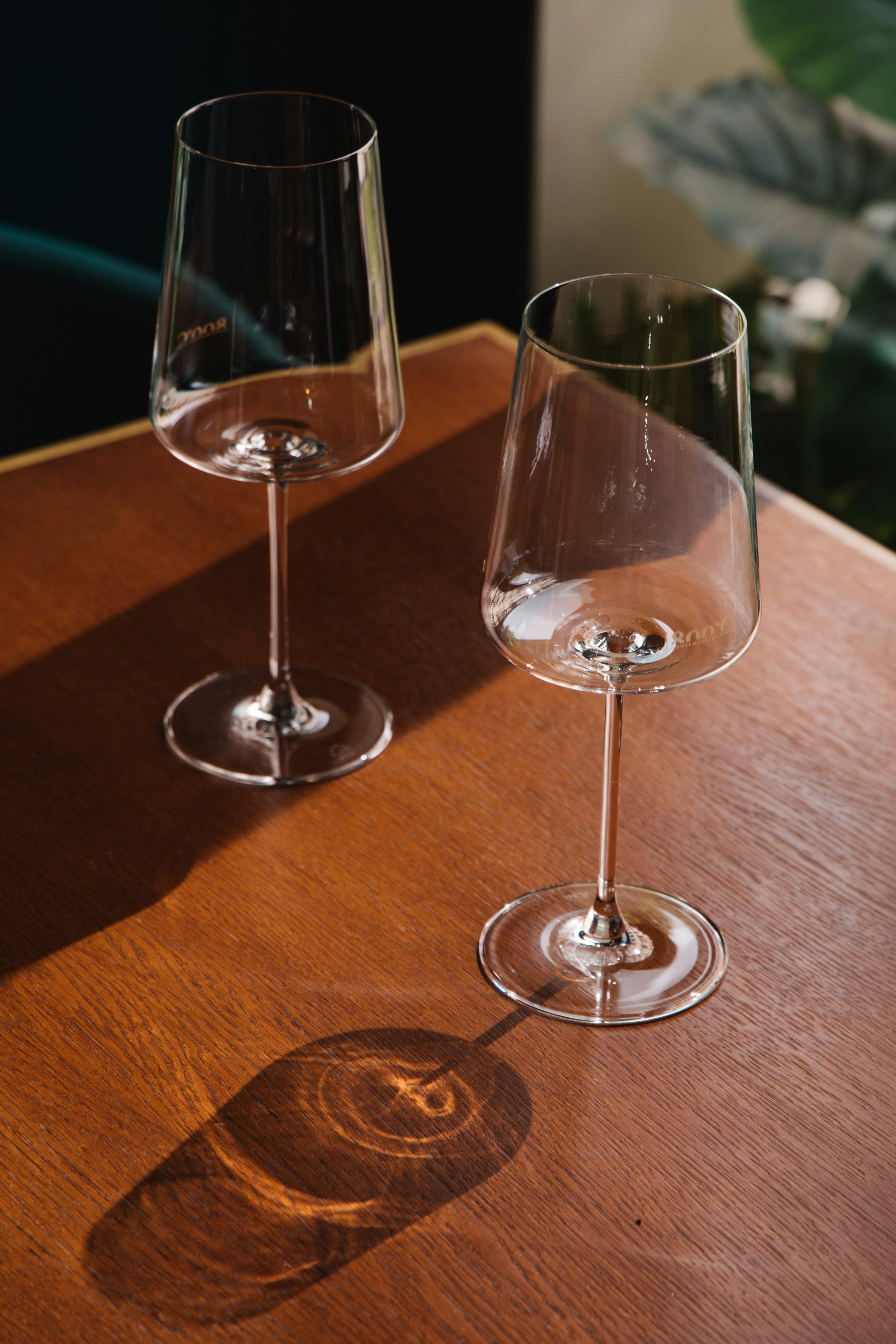 2 clear wine glasses on brown wooden table