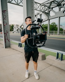 A videographer filming a large bridge under construction.