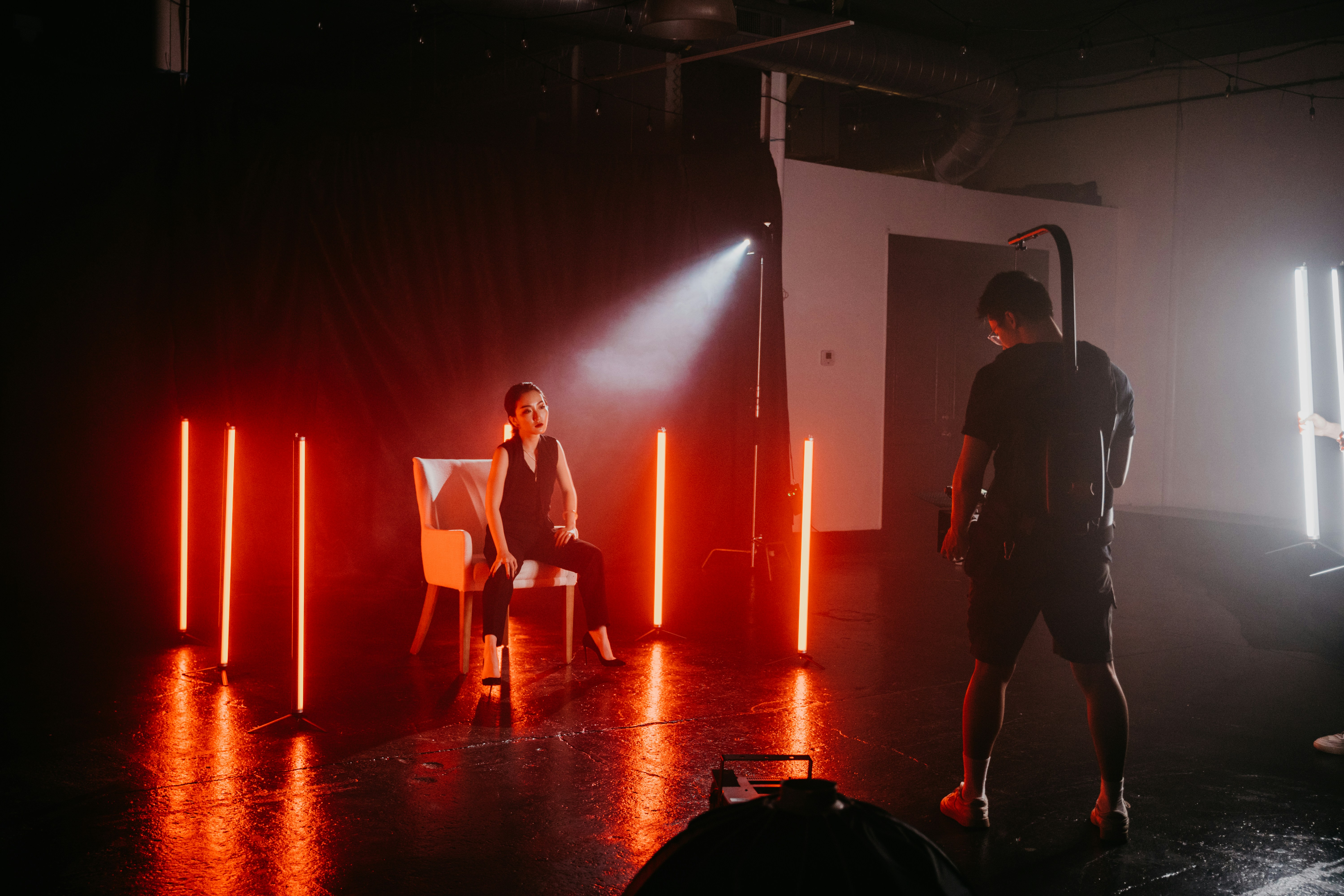 man in black jacket standing on brown wooden floor
