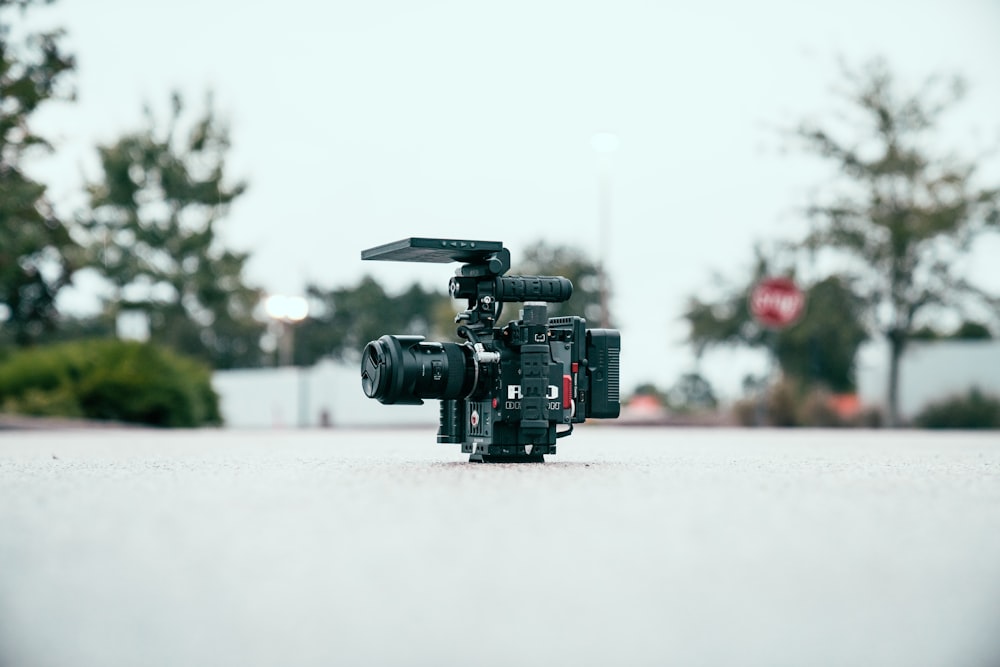 black dslr camera on gray pavement