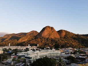 white concrete buildings near brown mountain under blue sky during daytime