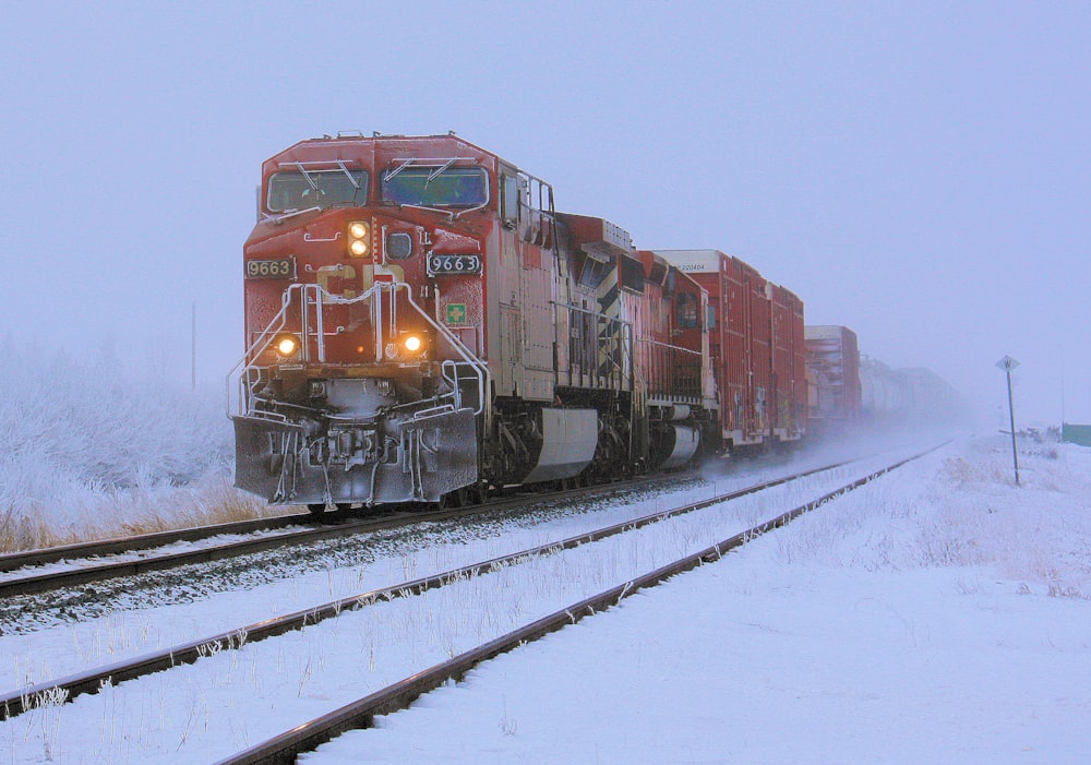 red train on rail tracks during daytime