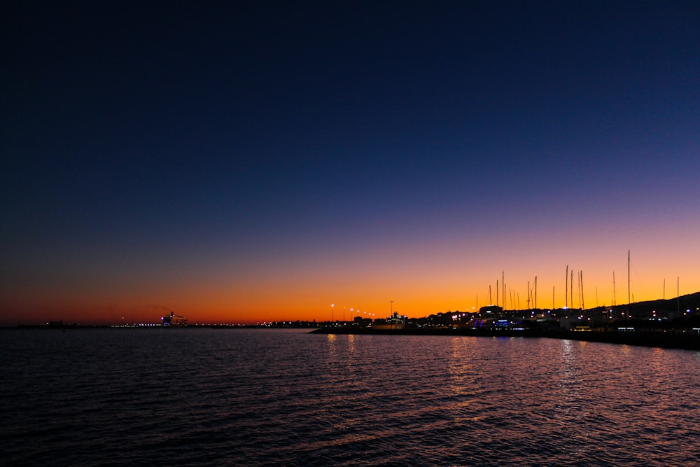 silhouette of boat on sea during sunset