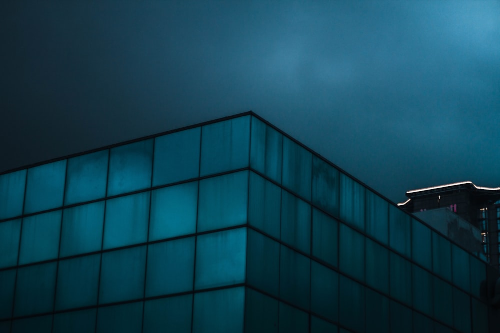 blue glass walled building during night time