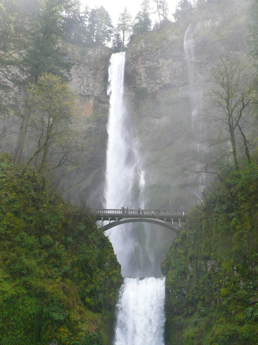 waterfalls under bridge during daytime