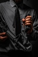 man in black leather jacket holding black rifle