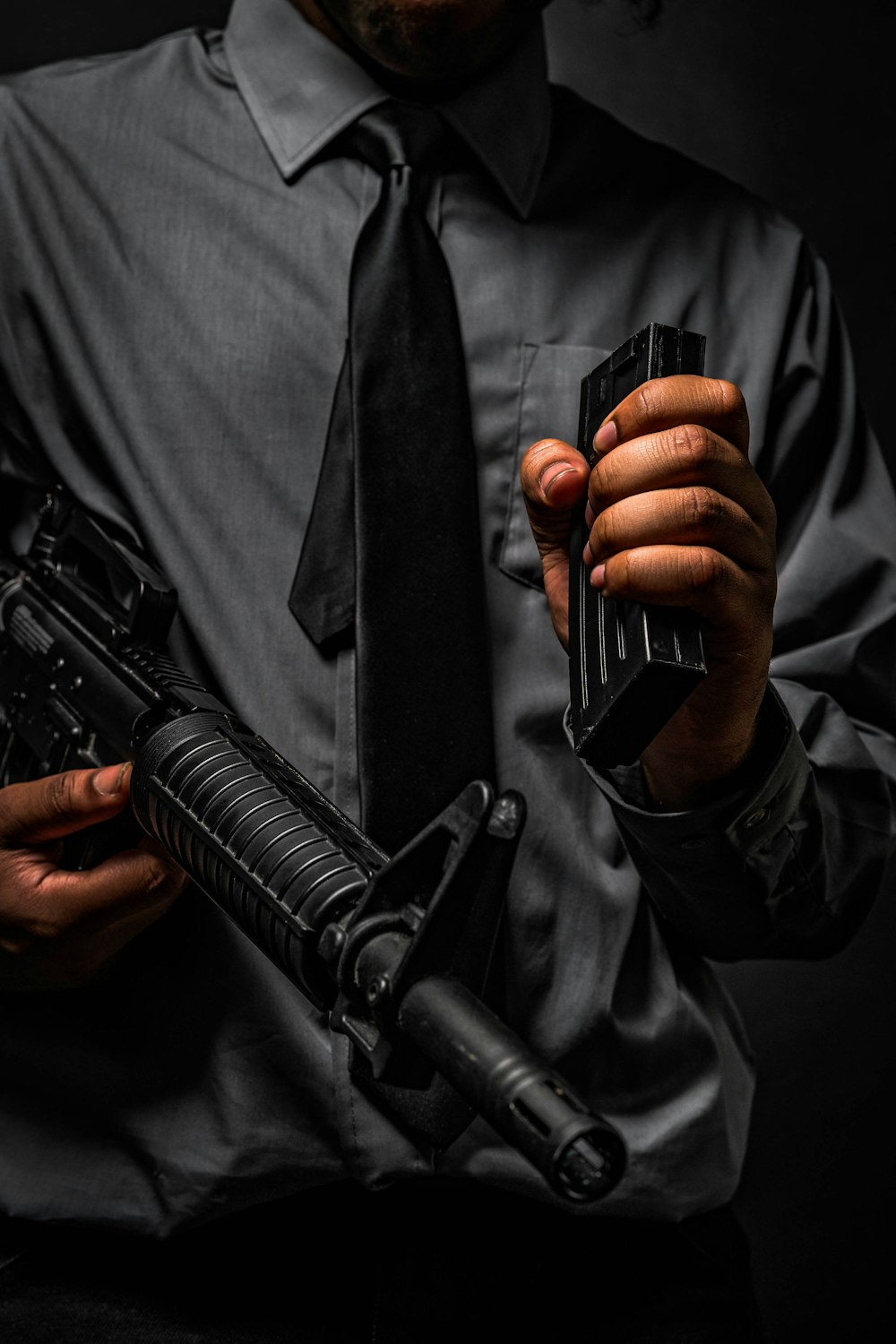Mann in schwarzer Lederjacke mit schwarzem Gewehr