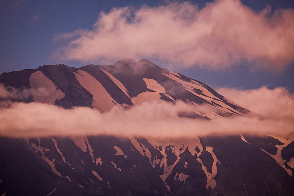 白い雲の下の茶色と白の山