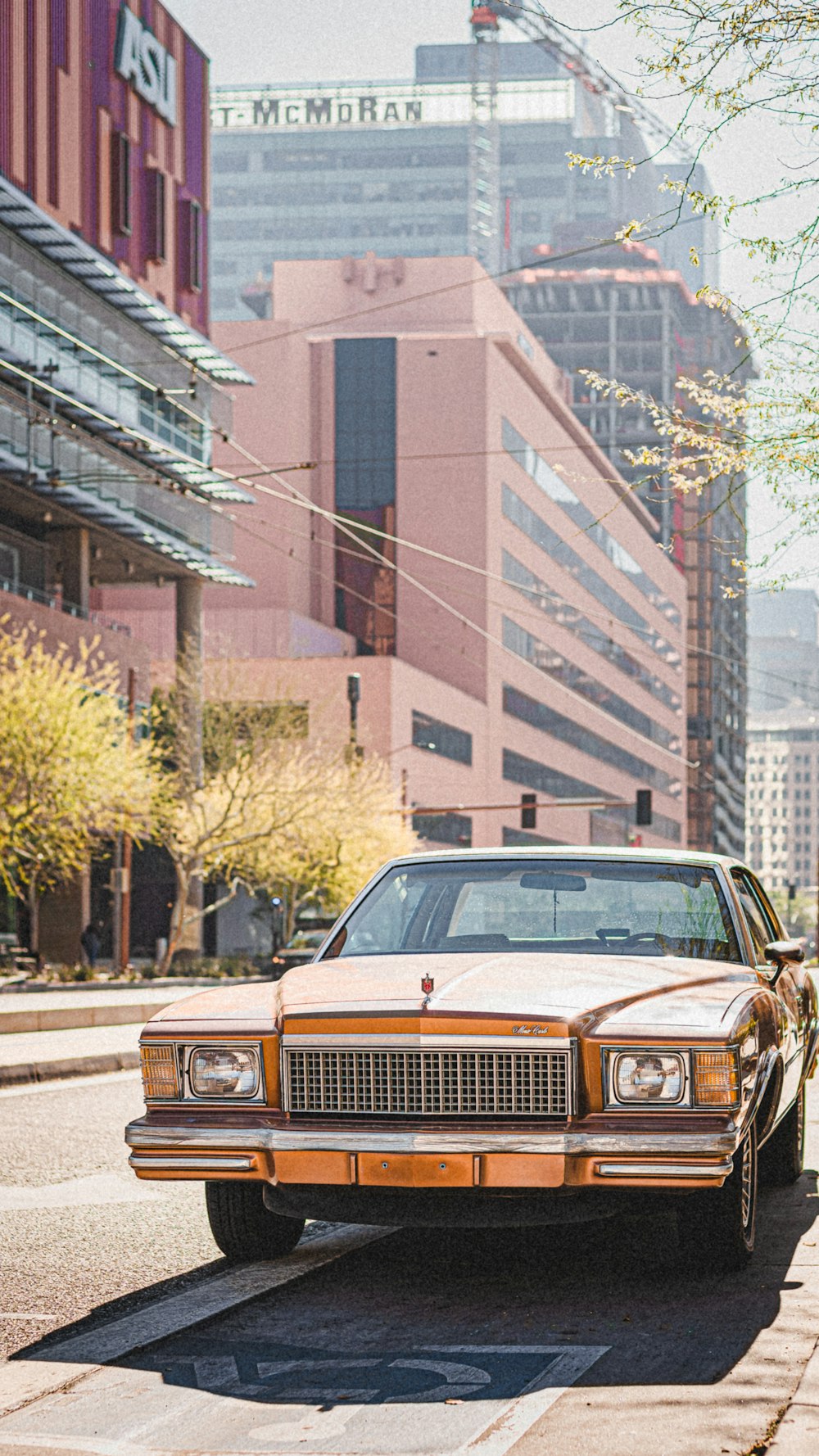 Voiture classique marron et blanche garée près du bâtiment brun pendant la journée