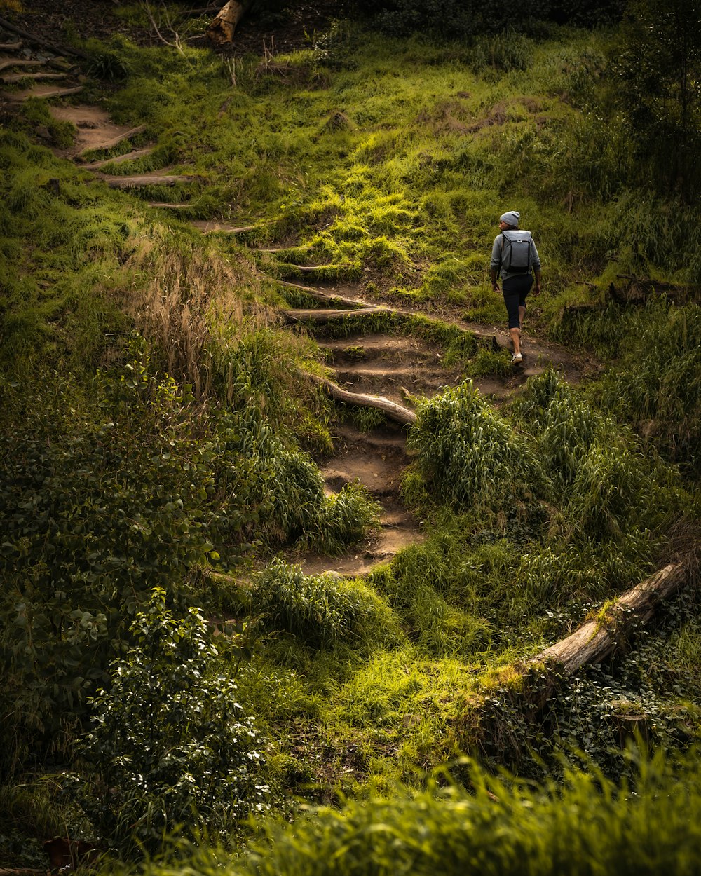 man in black jacket walking on dirt road