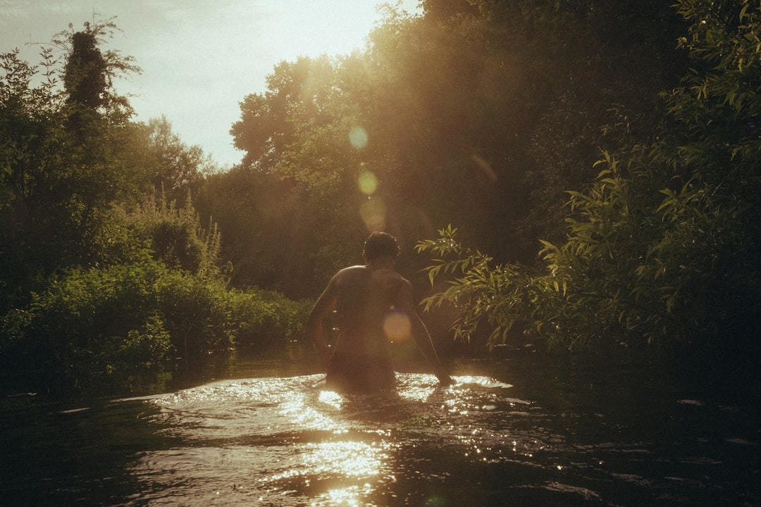 man in black shorts standing on river during daytime, River walks in the south of the UK. 