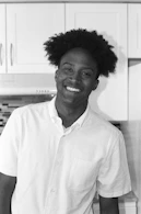 A smiling person handing a homemade meal to a neighbor in a cozy kitchen.
