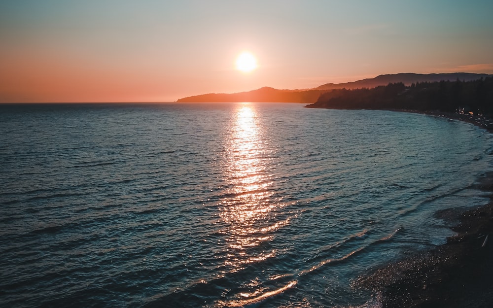 body of water during sunset