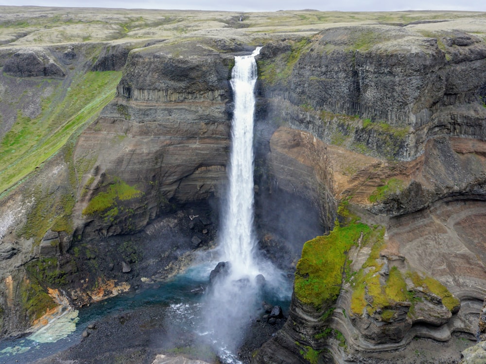 waterfalls on brown rocky mountain during daytime