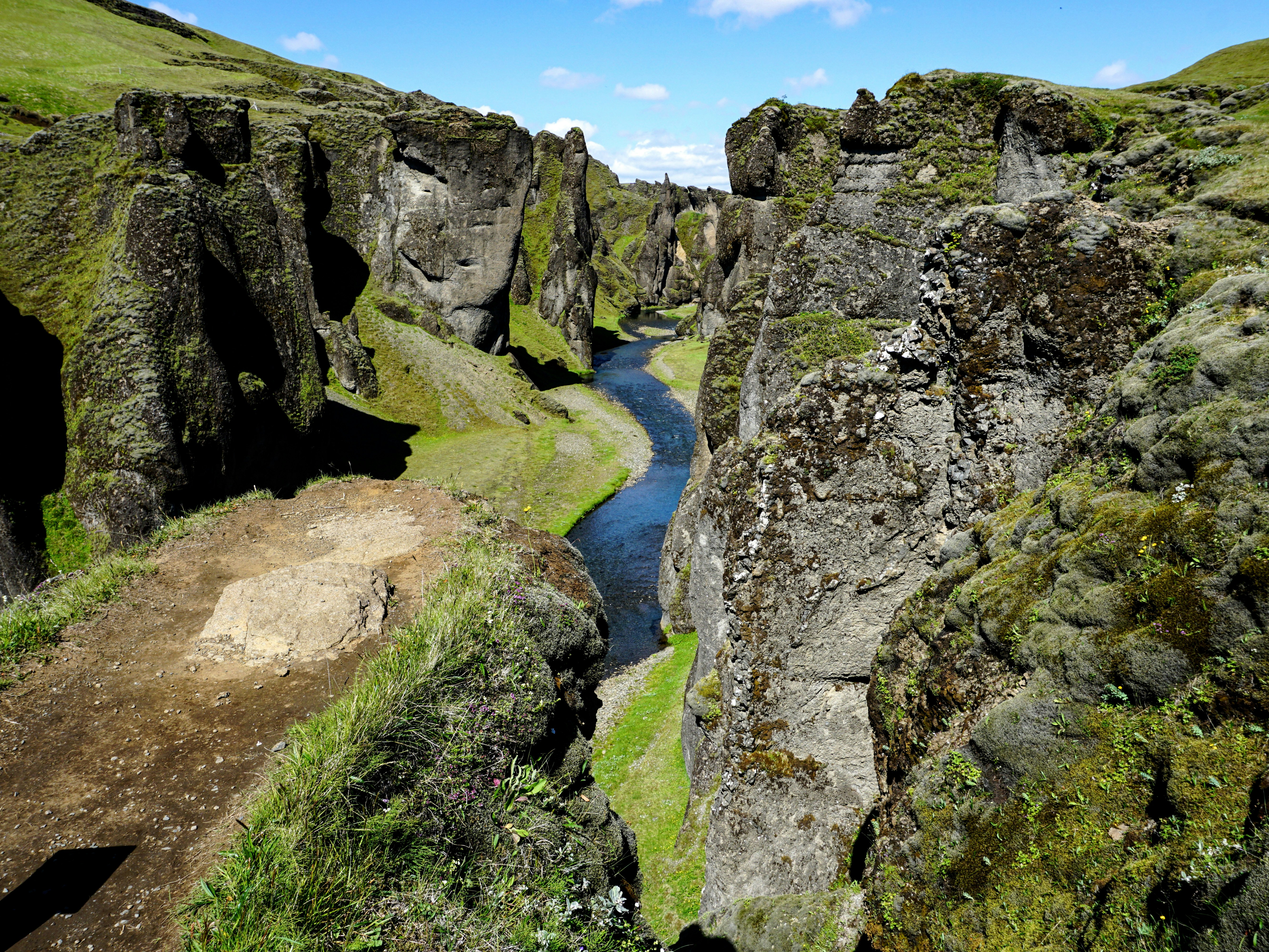 green grass and gray rocky mountain beside river during daytime wanderer teams background
