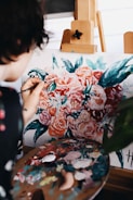 woman in red and white floral dress painting