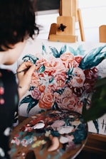 woman in red and white floral dress painting