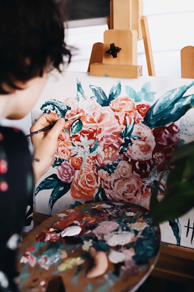 woman in red and white floral dress painting