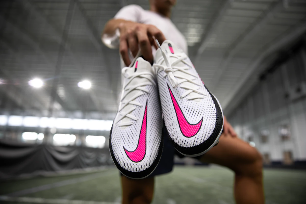 Close-up of pink and white football boots, the bold colourway trending across World Cup 2026 pitches