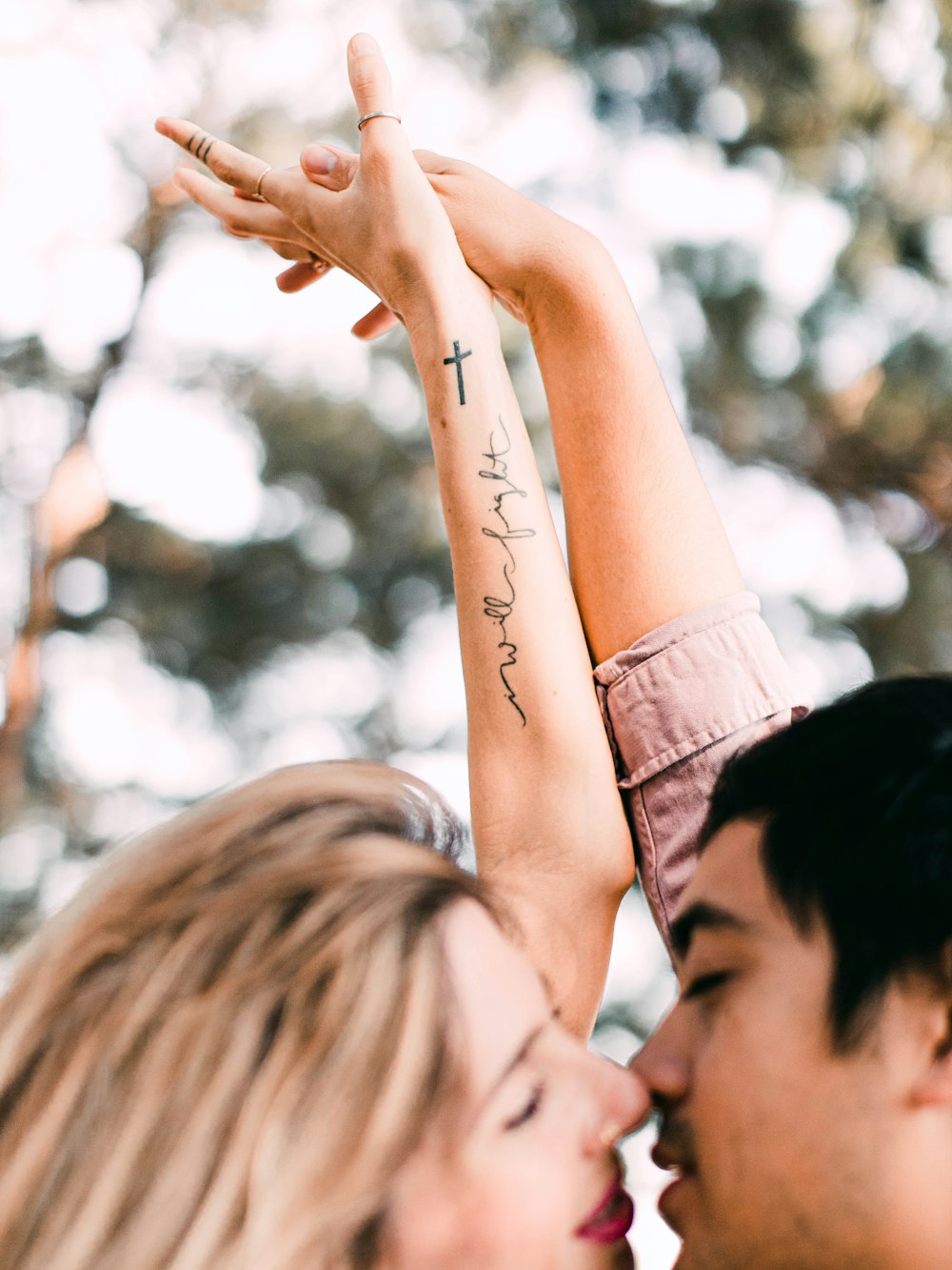 Frau im schwarzen Hemd mit Tattoo auf dem linken Arm