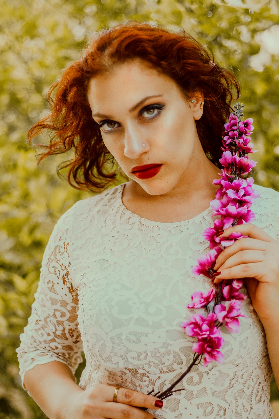 woman in white crew neck long sleeve shirt holding purple flowers