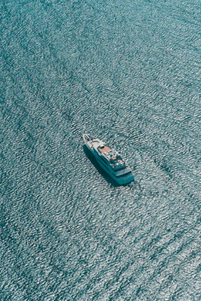 A sleek efoil gliding over deep navy waters under a clear sky, framed by a minimalist yacht deck.