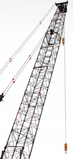 A basket crane lifting tools for electrical work on a tall building.