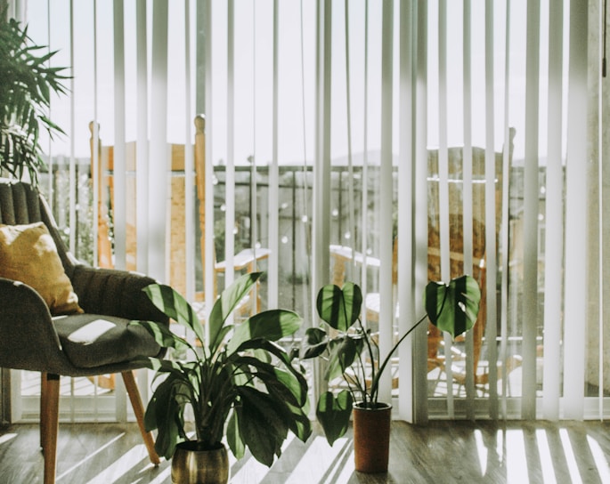 A cozy living room with bamboo chick blinds softly filtering sunlight through the window.