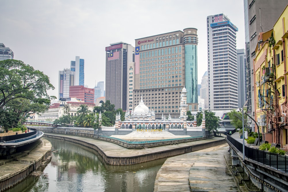 white and blue boat on river near city buildings during daytime