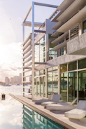 A modern waterfront property with large windows reflecting the harbor.