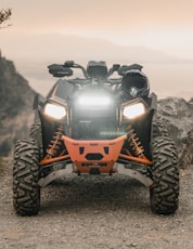 orange and black atv on gray rock