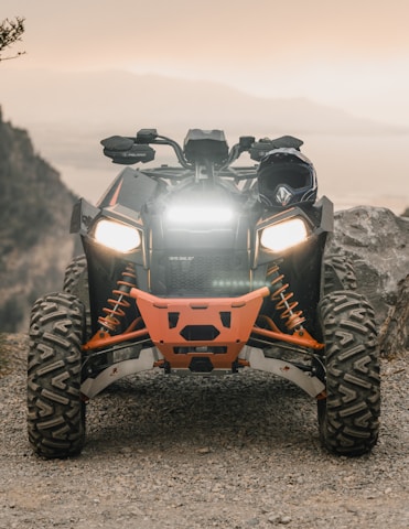 orange and black atv on gray rock