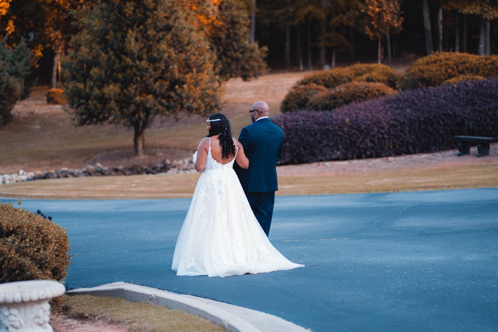 bride and groom kissing on road during daytime