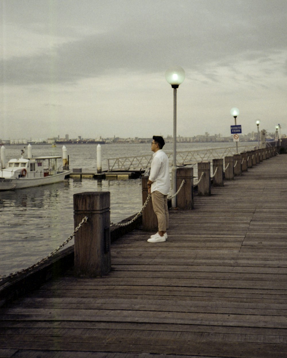 woman in white dress standing on wooden dock during daytime