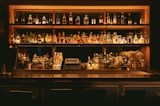 Backbar of liquor bottles in warm low light