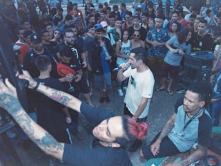 Crowd of enthusiastic youth gathered around a cypher circle outdoors.