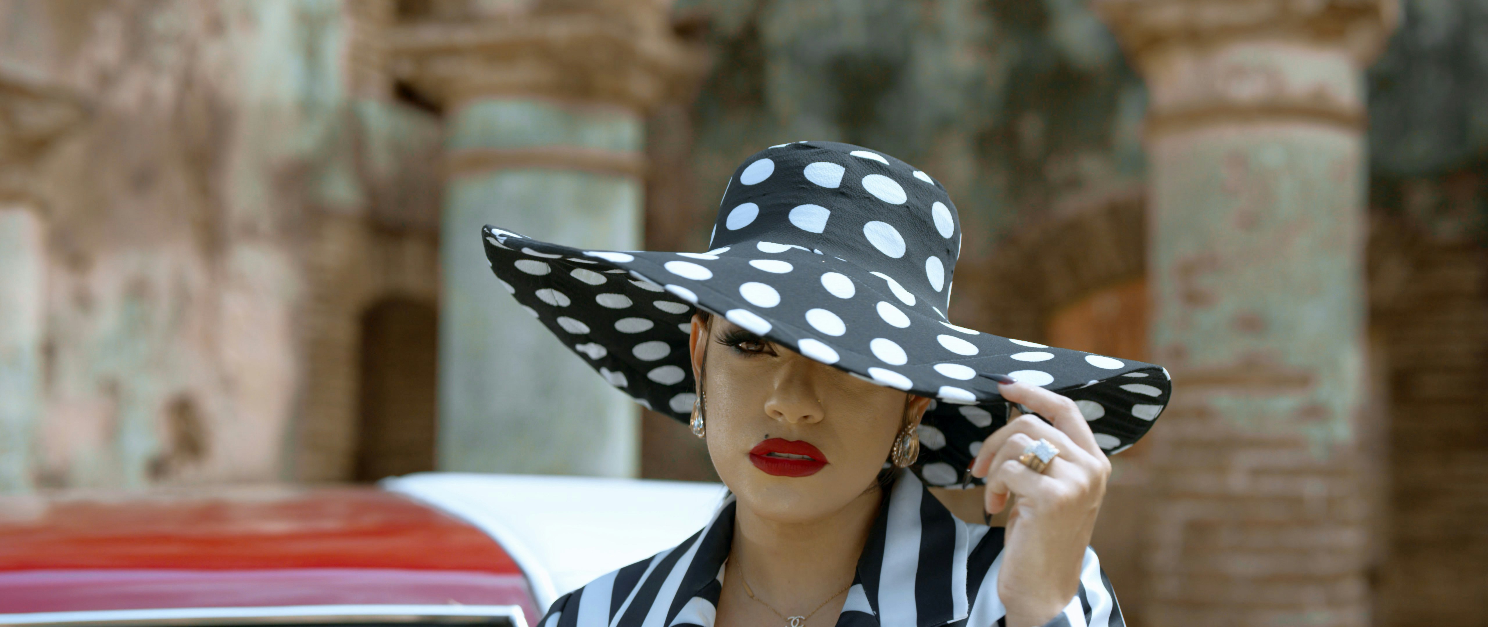 woman in black and white polka dot hat