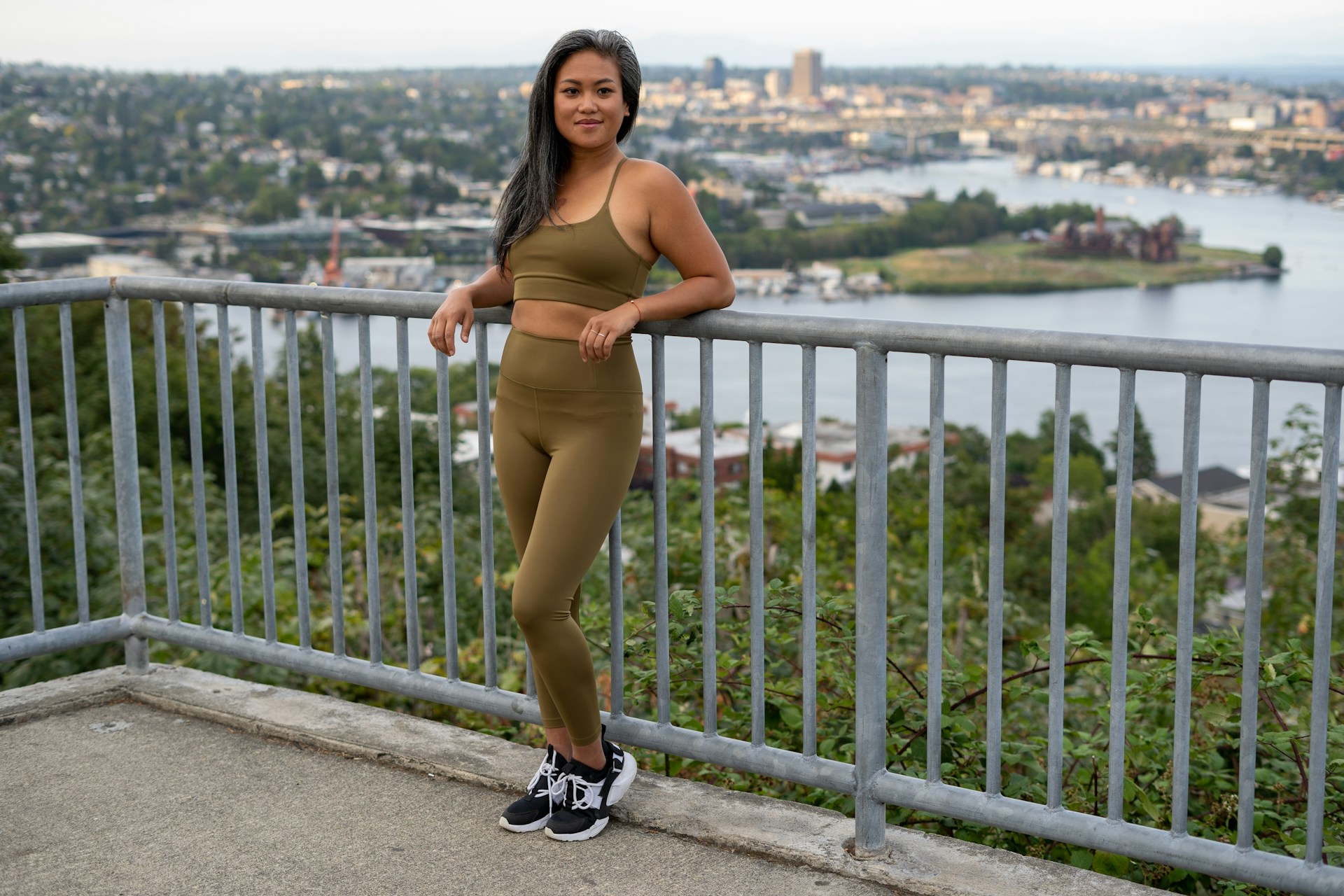 A social media influencer mid-workout, confidently showcasing branded activewear with vibrant cityscape in the background.