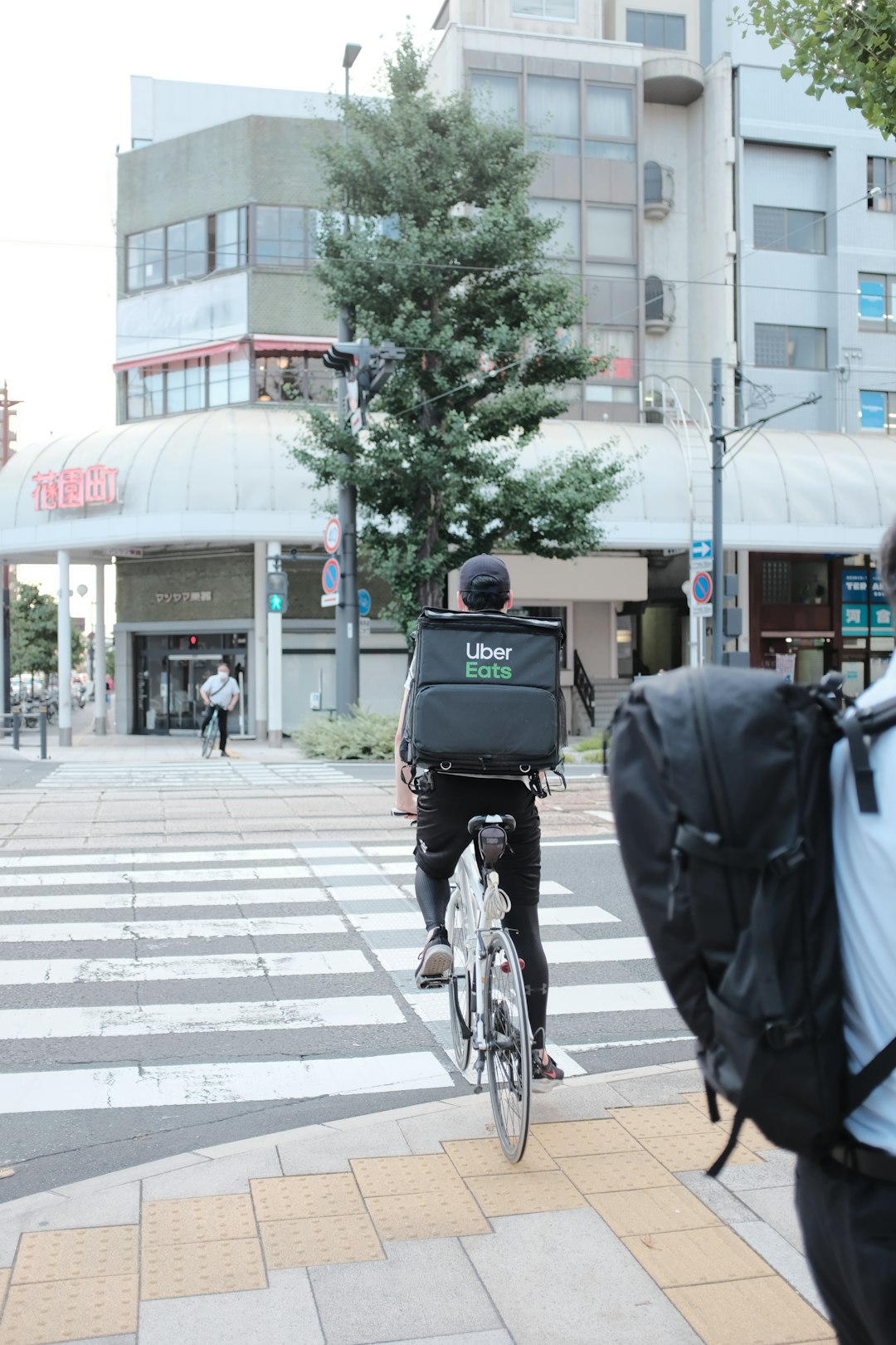 man in black jacket riding bicycle on sidewalk during daytime