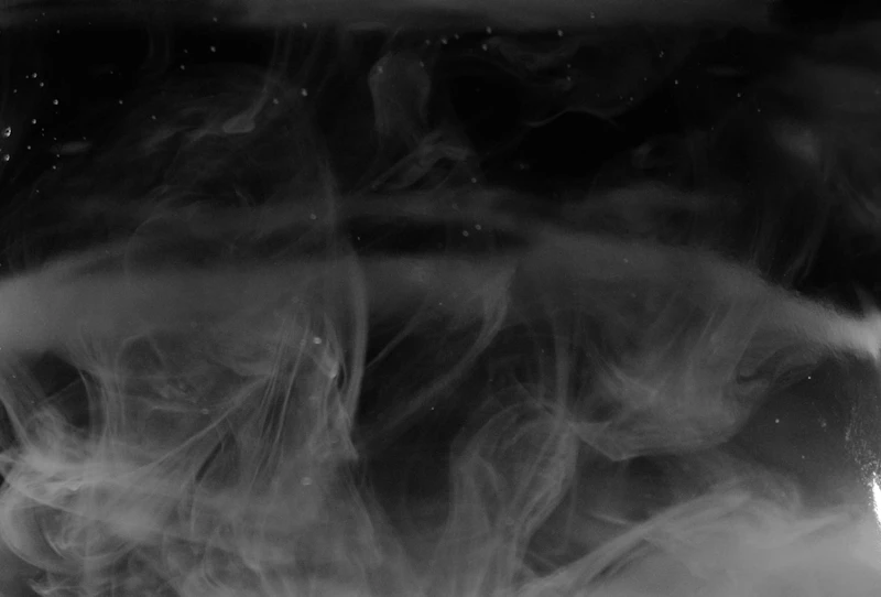 White smoke drifting across a black field