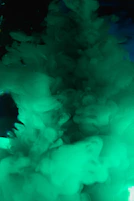 A close-up of a bubbling cauldron with green smoke swirling around, set against a dark forest backdrop.