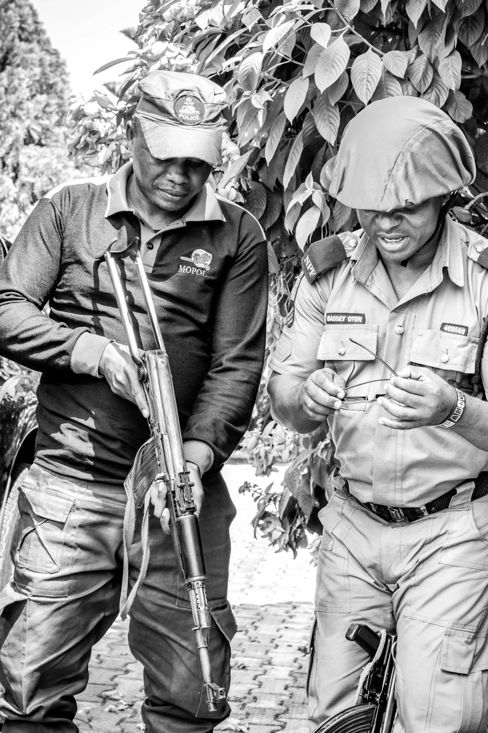 grayscale photo of 2 men in camouflage uniform holding rifle