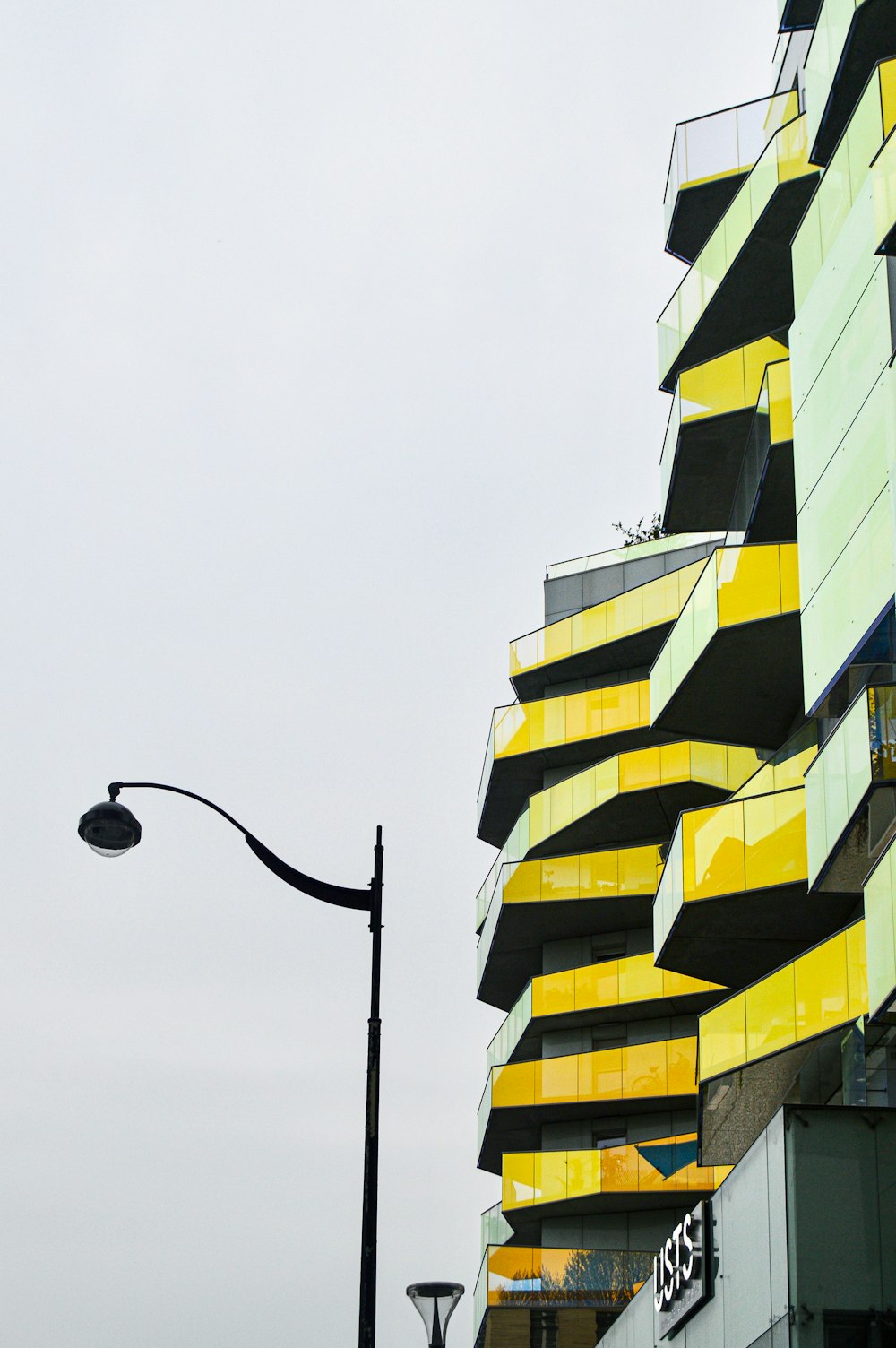 black street light near yellow and white building during daytime