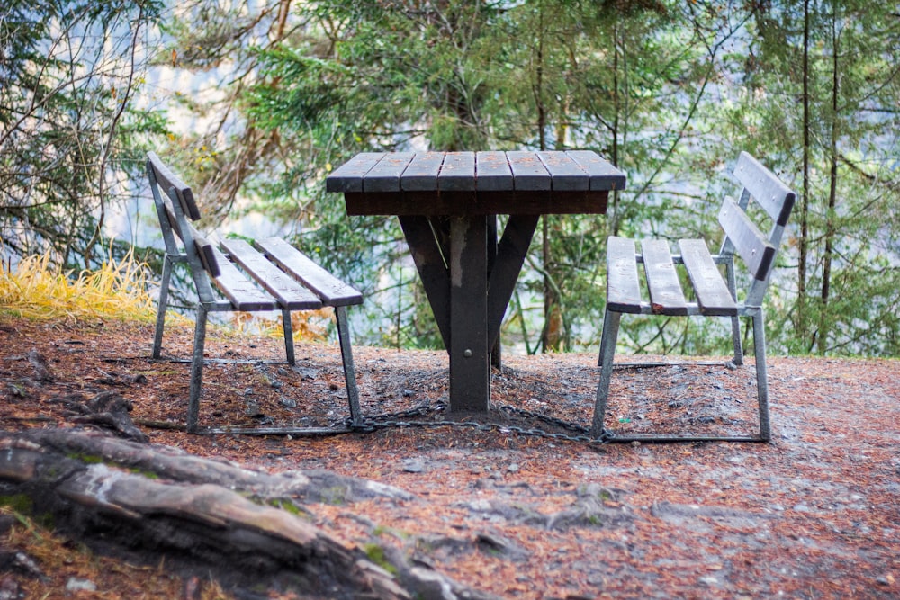 brown wooden picnic table on brown dirt ground