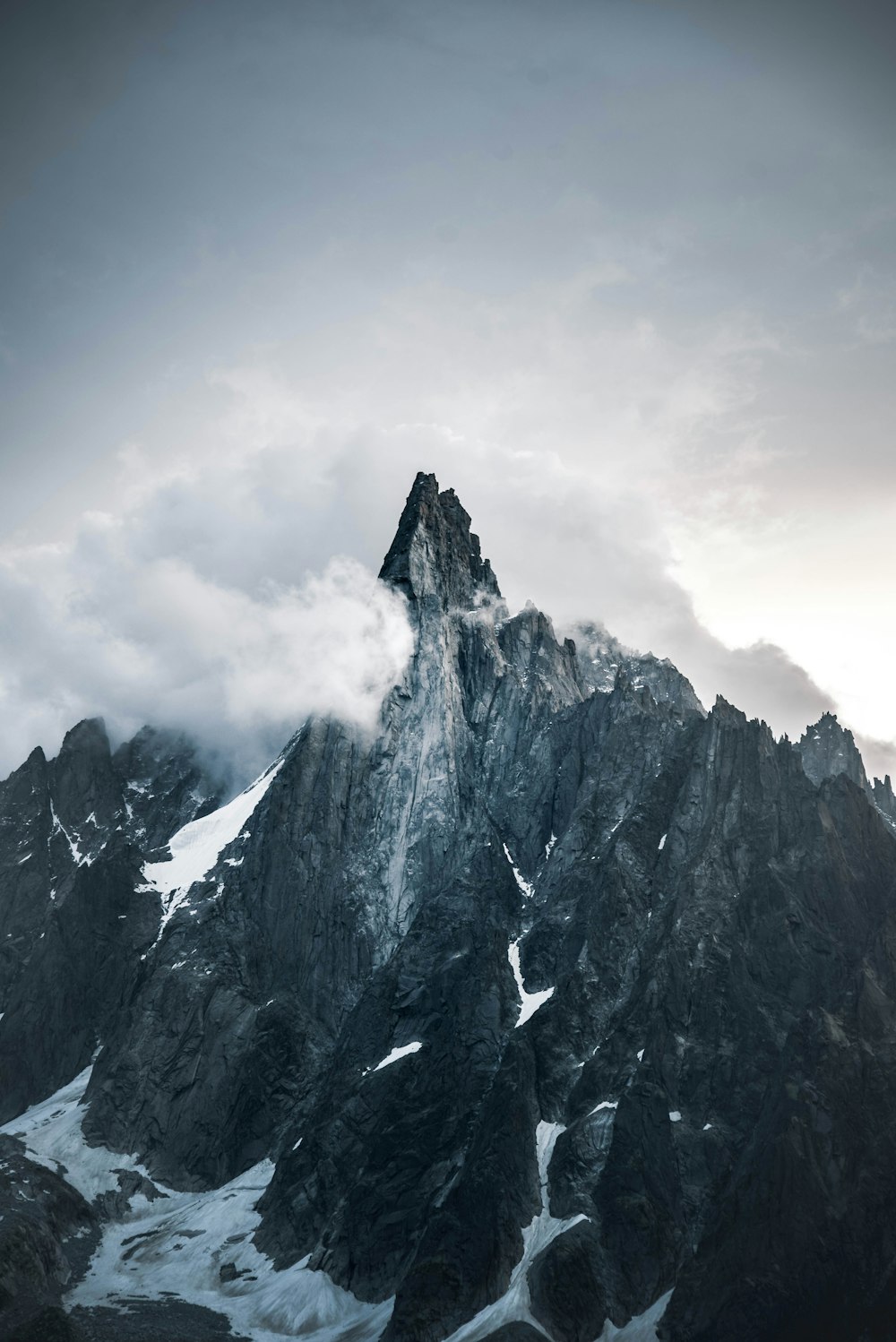 gray rocky mountain under white clouds during daytime