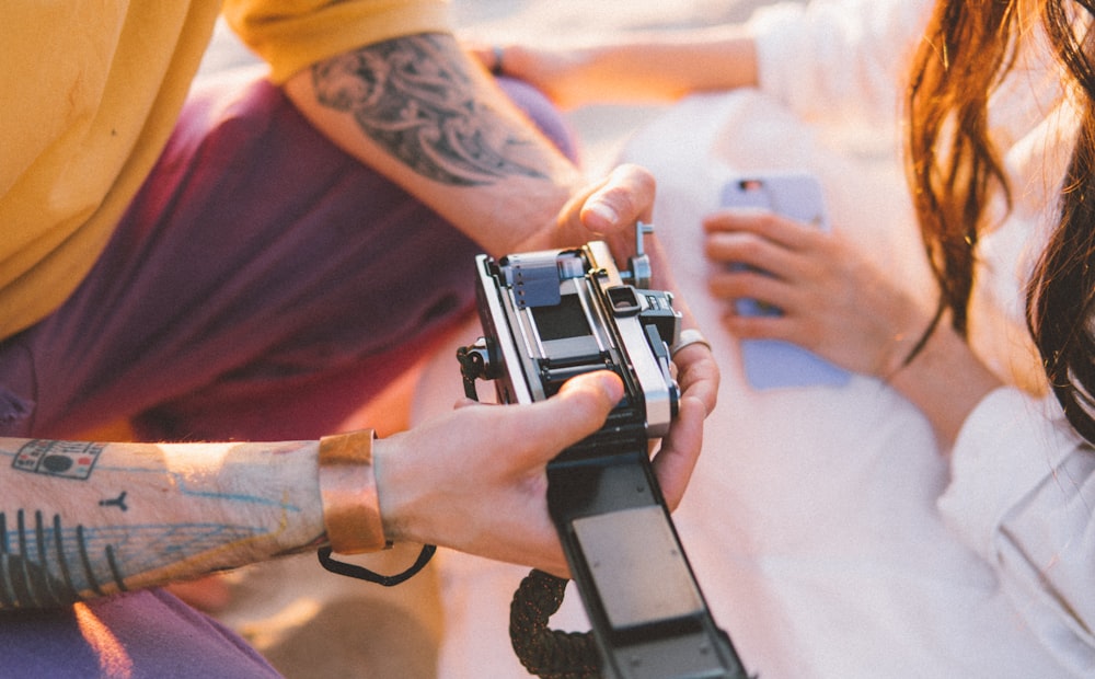 person holding black and silver camera